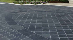 A driveway with dark gray tiles