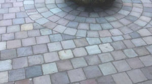 A driveway with light gray tiles