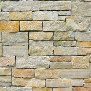 A wall with gray and light brown bricks