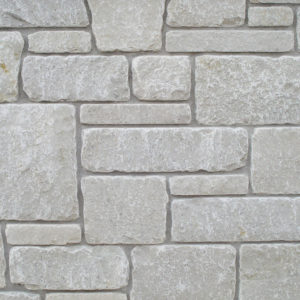 A wall with stone bricks of different sizes